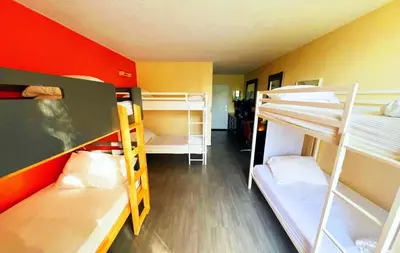 a room with three bunk beds in a room at Bposhtels Orlando Florida Mall in Orlando