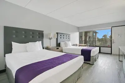 a hotel room with two beds and a window at Home 1 Suites Extended Stay - Kissimmee in Kissimmee