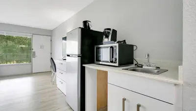 a kitchen with a sink and a refrigerator at Home 1 Suites Extended Stay - Kissimmee in Kissimmee