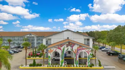 a building with a painting on it in a parking lot at Home 1 Suites Extended Stay - Kissimmee in Kissimmee