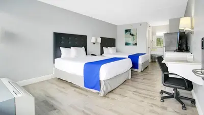 a hotel room with two beds and a desk at Home 1 Suites Extended Stay - Kissimmee in Kissimmee