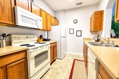 a kitchen with white appliances and wooden cabinets at Windsor Hills Resort 3 Bedroom Condo 5 Minutes to Disney in Orlando
