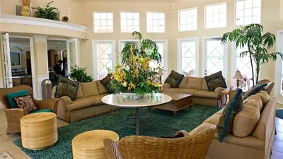 a living room with couches and a table with flowers at Windsor Palms Resort 3 Bedroom Condo 6 Miles to Disney in Kissimmee
