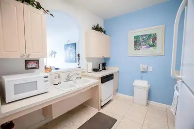 a kitchen with blue walls and white cabinets and a sink at Windsor Palms Resort 3 Bedroom Condo 6 Miles to Disney in Kissimmee
