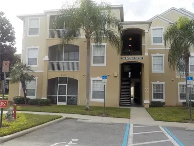 a building with a palm tree in front of it at Windsor Palms Resort 3 Bedroom Condo 6 Miles to Disney in Kissimmee