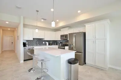 a kitchen with white cabinets and a white counter top at Great apartment in Storey Lake resort with great amenities next to Disney! in Kissimmee