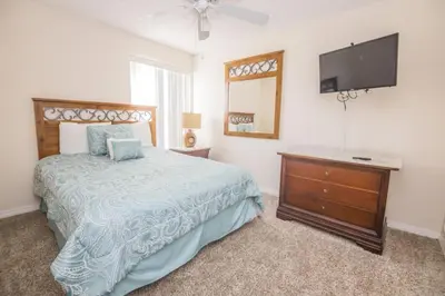 a bedroom with a bed and a flat screen tv at Royal Palm Bay 3 Bedroom Condo Resort Pool 10 Min Disney in Kissimmee