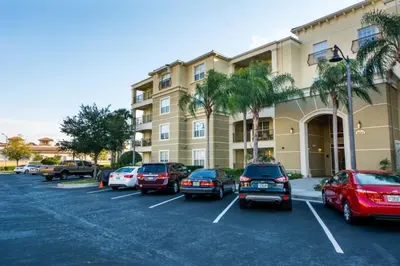 a parking lot with cars parked in front of a building at Vista Cay Resort 3 Bedroom Condo 2 Miles to Universal Orlando in Orlando