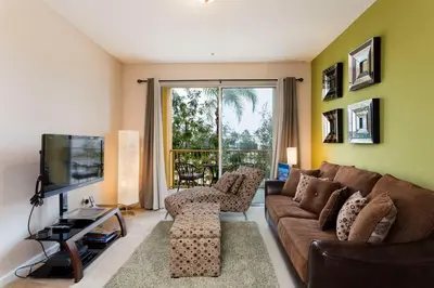 a living room with a couch and a tv at Spacious 2BR 2BA with Balcony 5 Mins to Convention Center & Epic Universe in Orlando