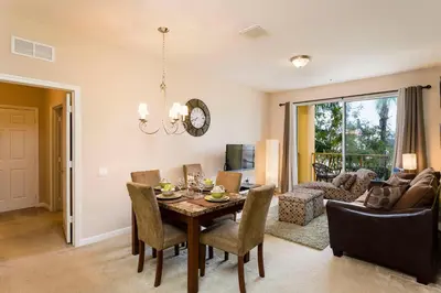 a dining room and living room with a table and chairs at Spacious 2BR 2BA with Balcony 5 Mins to Convention Center & Epic Universe in Orlando