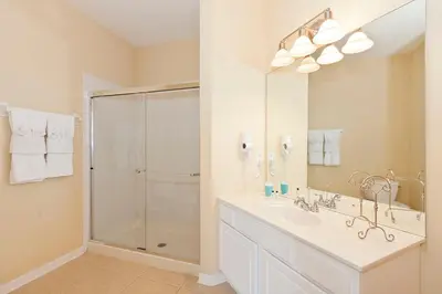 a white bathroom with a shower and a sink at 2Br 2Bath Condo Balcony 5min Conv Center 1496ft in Orlando