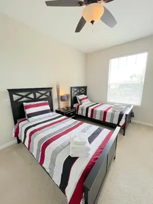 a bedroom with two beds and a ceiling fan at 2Br 2Bath Condo Balcony 5min Conv Center 1496ft in Orlando