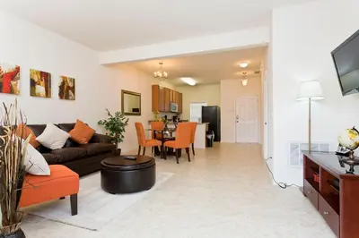 a living room with a couch and a table at 3Br 3Bath Townhome BBQ Pool 15min Disney 1291ft in Kissimmee