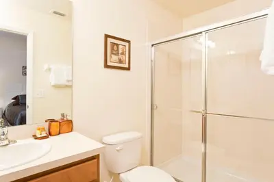 a bathroom with a shower and a toilet and a sink at 3Br 3Bath Townhome BBQ Pool 15min Disney 1291ft in Kissimmee