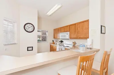 a kitchen with a counter and a clock on the wall at 3Br 3Bath Private Townhome 10min Disney 1270ft in Kissimmee