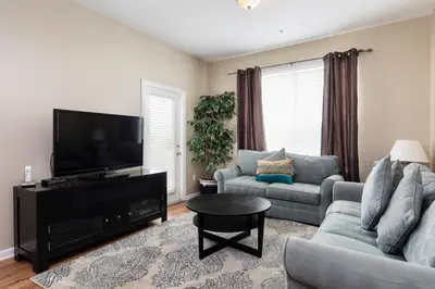 a living room with a couch and a tv at 3Br 2Bath Condo Balcony 5min Conv Center 1388ft in Orlando