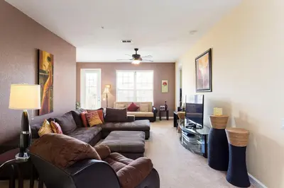 a living room with a couch and a tv at 3Br 2Bath Condo Balcony 5min Conv Center 2087ft in Orlando
