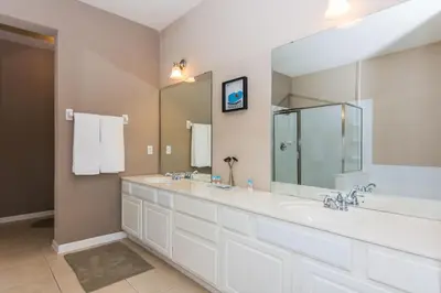 a bathroom with three sinks and a large mirror at Spacious Vista Cay Condo near Universal Studios in Orlando