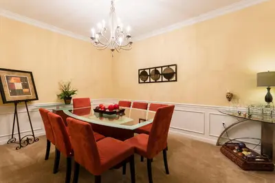 a dining room with a table and chairs and a chandelier at 4Br 2Bath Condo Balcony 5min Conv Center 2020ft in Orlando