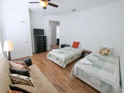 a living room with a couch and a bed at 4Br 2Bath Condo Balcony 5min Conv Center 2020ft in Orlando