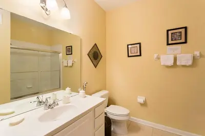 a bathroom with a sink and a toilet and a mirror at 4Br 2Bath Condo Balcony 5min Conv Center 2020ft in Orlando