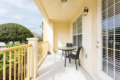 a patio with a table and chairs on a balcony at Renovated 4Br Condo 5min Conv Center in Orlando