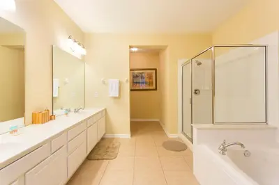 a large bathroom with two sinks and a shower at Renovated 4Br Condo 5min Conv Center in Orlando
