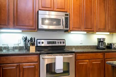 a kitchen with a stove and a microwave at Renovated 4Br Condo 5min Conv Center in Orlando