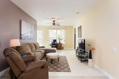 a living room with a couch and a tv at Renovated 4Br Condo 5min Conv Center in Orlando