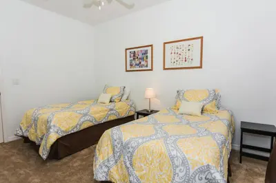a bedroom with two beds and a table with a lamp at 5Br 3Bath Private Townhome 13min Disney 1496ft in Kissimmee