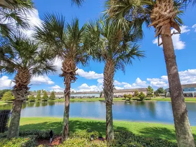 a group of palm trees in front of a lake at 5Br 3Bath Private Townhome 13min Disney 1496ft in Kissimmee