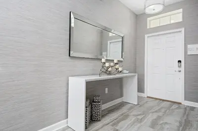 a living room with a fireplace and a mirror at 5Br 5Bath Pvt Home BBQ Pool 10min Disney 3077ft in Kissimmee