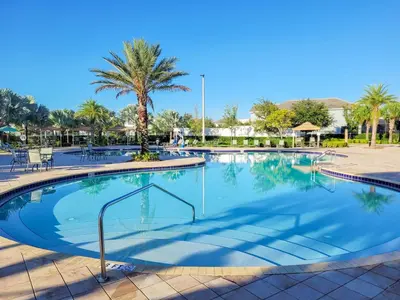 a large swimming pool at a resort with a palm tree at 5Br 5Bath Pvt Home BBQ Pool 10min Disney 3077ft in Kissimmee