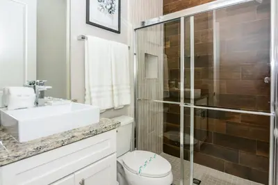 a bathroom with a toilet and a sink and a shower at 3 BR 3BA 1678ft 5min Disneyworld Resort style in Orlando