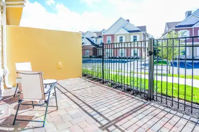 a patio with a fence and a table and chairs at 3 BR 3BA 1678ft 5min Disneyworld Resort style in Orlando