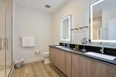 a bathroom with a sink and a toilet and a mirror at Great 4 bedroom townhouse in lux resort Hidden Forest, with private pool! in Orlando