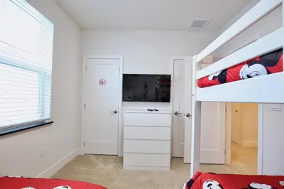 a bedroom with a bunk bed and a tv at Great 4 bedroom townhouse in lux resort Hidden Forest, with private pool! in Orlando