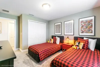 a bedroom with two beds and a table with a lamp at 4 Bed Storey Lake Resort With Lazy River townhouse in Kissimmee