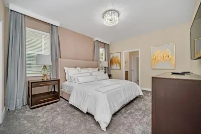 a bedroom with a large white bed and a table at 9 Bed Storey Lake Villa Pictures Coming Soon home in Kissimmee