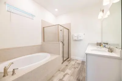 a white bathroom with a tub and a sink at Lovely Cottage Near Disney With Margaritaville Resort & Island H20 Access - 8145Su in Orlando