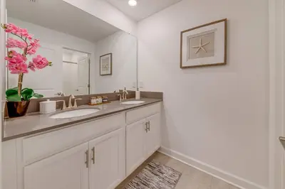 a bathroom with two sinks and a large mirror at NEWLY LISTED Townhouse Storey Lake, Free Waterpark in Kissimmee