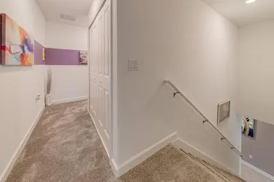 a hallway with white walls and a stair case at NEWLY LISTED Townhouse Storey Lake, Free Waterpark in Kissimmee