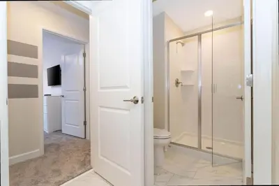 a bathroom with a toilet and a glass shower at Gorgeous 4 Bd w/ Pool at Champions Gate Resort 1020 in Orlando