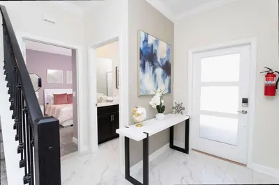 a white living room with a table and a bedroom at Gorgeous 4 Bd w/ Pool at Champions Gate Resort 1020 in Orlando