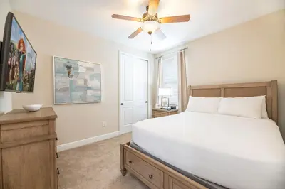 a bedroom with a white bed and a ceiling fan at Modern Home With Pool Table Near Disney With Waterpark & Resort Access At Encore Resort - 7644Ff in Kissimmee