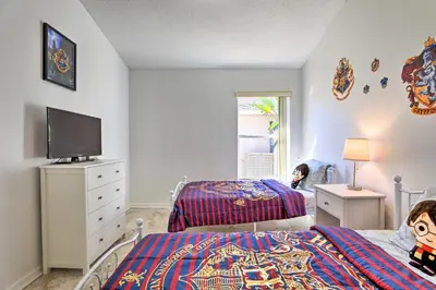 a bedroom with two beds and a flat screen tv at 8 Mi to Disney World Home with Lanai and Game Room! in Kissimmee