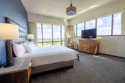 a hotel room with a bed and a flat screen tv at Drury Plaza Hotel Orlando - Disney Springs Area in Orlando