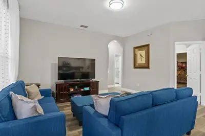 a living room with two blue couches and a tv at WindsorHills Villa Pool Resort Amenities Minutes to Disney in Orlando