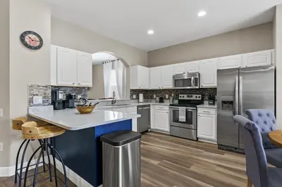a kitchen with white cabinets and a blue island at WindsorHills Villa Pool Resort Amenities Minutes to Disney in Orlando