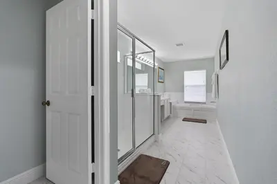a bathroom with a walk in shower and a white door at WindsorHills Villa Pool Resort Amenities Minutes to Disney in Orlando